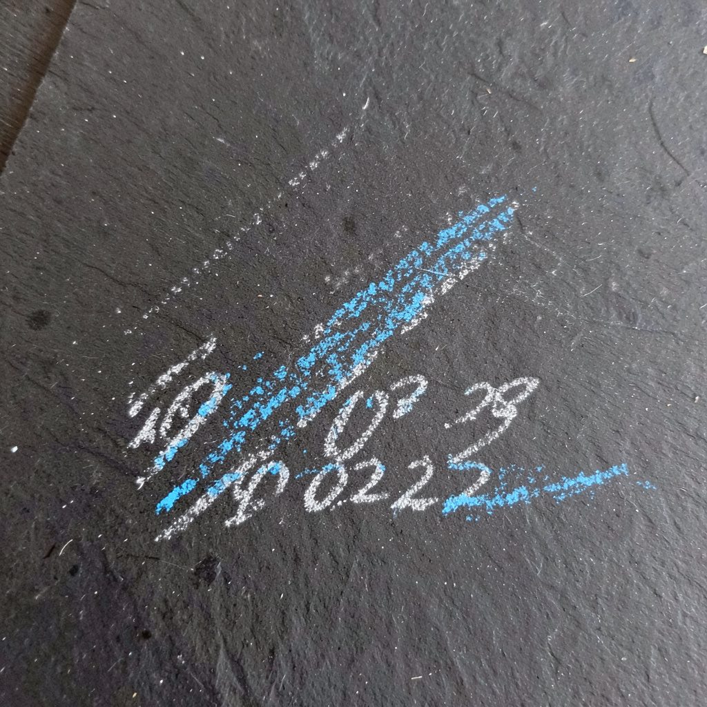 Chalk drawing on a dark slate board showing simple geometric shapes and arrows representing a small network diagram, in soft white and pale blue chalk against deep charcoal